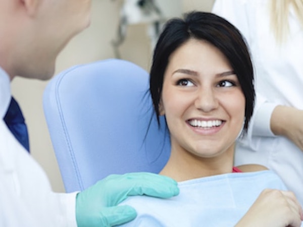Woman with dark hair sitting in dental chair as she is about to choose from our services